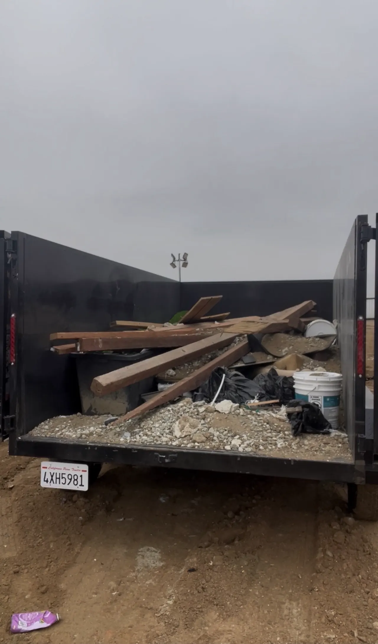 Trailer loaded with lumber, buckets and construction debris