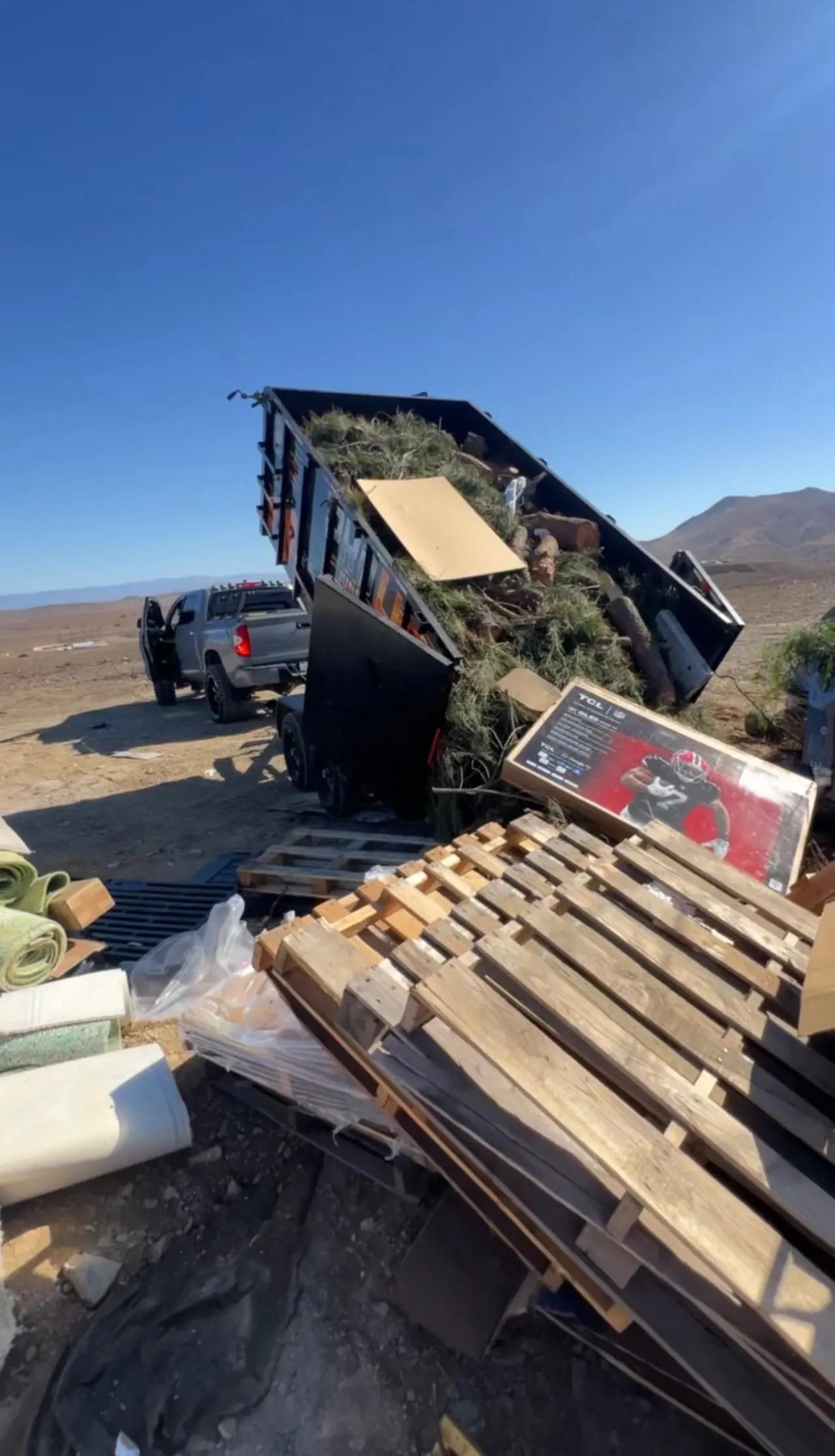 Dump trailer tipped up, unloading branches and yard waste